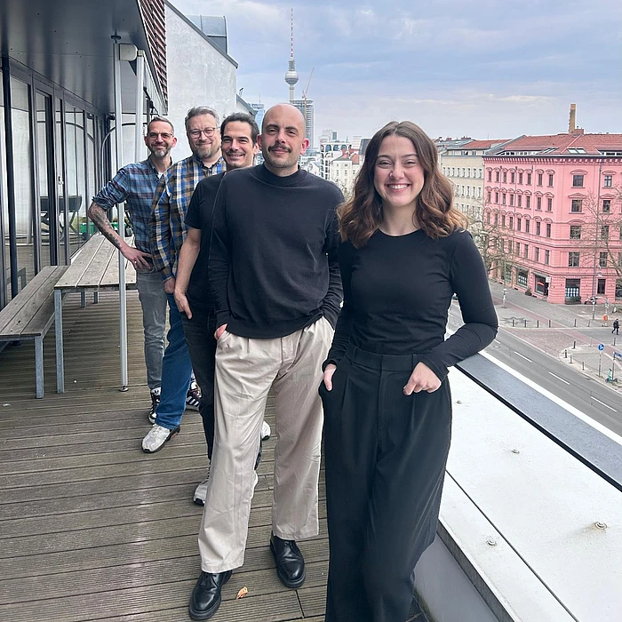 TYPO3 marketing sprint team posing on a Berlin rooftop terrace with the city skyline and TV Tower in the background.