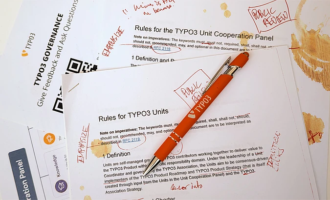 TYPO3 governance documents with red pen and handwritten annotations on rules and cooperation panel guidelines