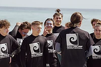 Group of surfers gathering for a surf lesson on the beach