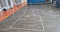 Taped floor sections with colored labels for a group activity.