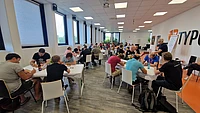 People seated at tables during a group workshop in a bright conference room.