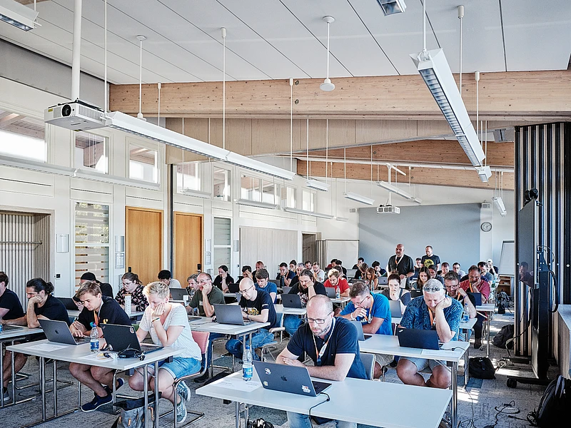 Certification with attendees using laptops in a bright room.