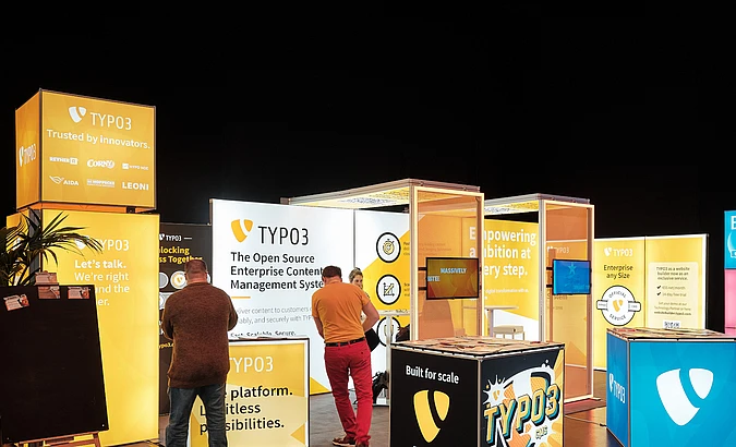 Colorful TYPO3 booth setup at an event.