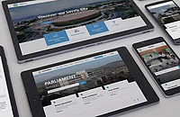 Multiple devices displaying Kigali City and Parliament websites with aerial city views and blue navigation elements