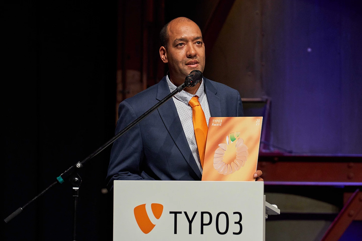 Jonathan Iroulin from Talan Solutions accepts award for the TYPO3 Website of the Year on stage.