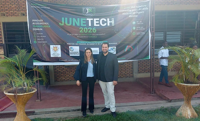 Two people standing in front of JuneTech 2026 banner at an innovation conference event