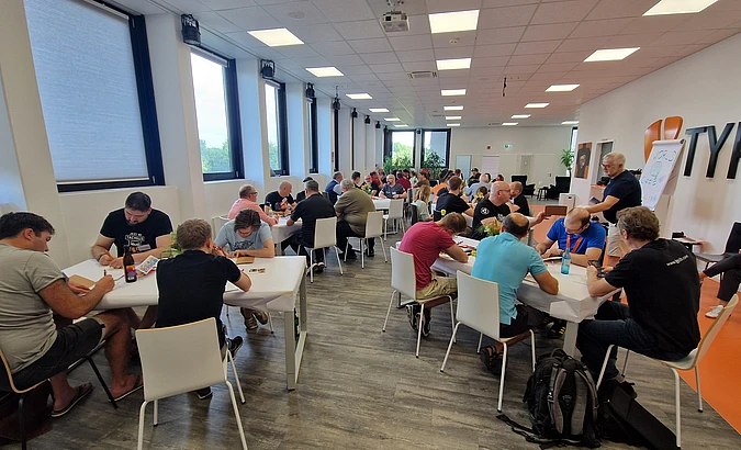 People seated at tables during a group workshop in a bright conference room.