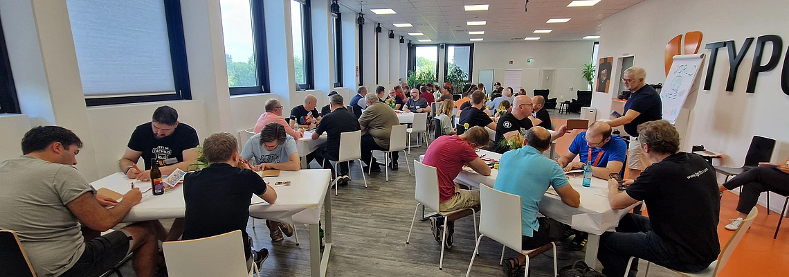 People seated at tables during a group workshop in a bright conference room.